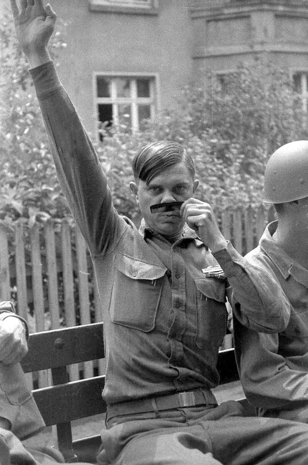 American soldier mocking Adolf Hitler with a makeshift mustache and salute